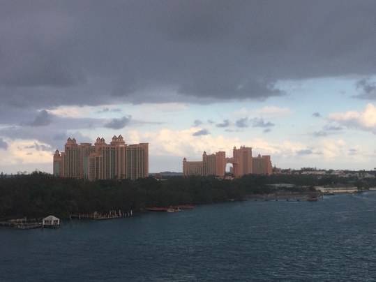A large pink resort across a harbor under a stormy sky