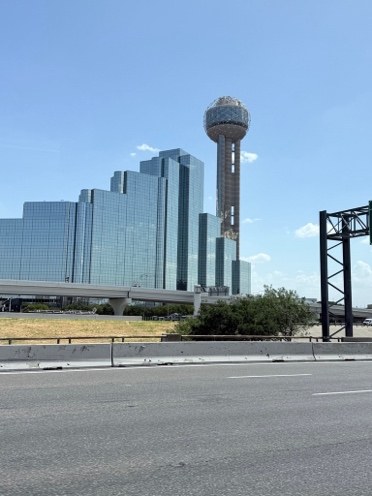 Reunion Tower and a glass hotel in Dallas seen from the highway