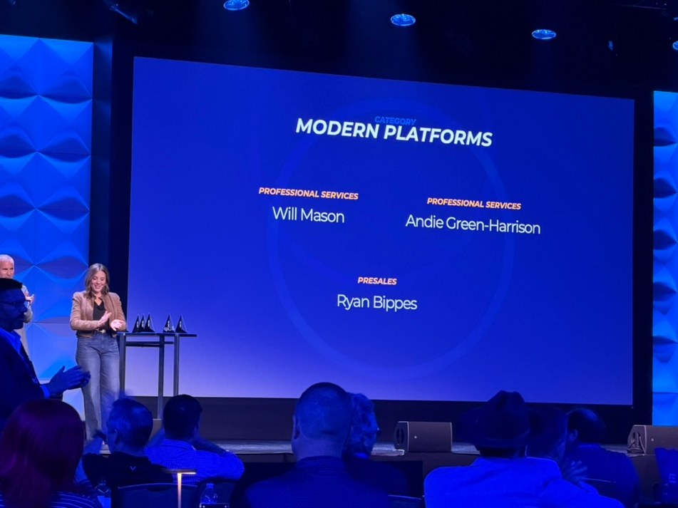 A conference stage with a screen reading Modern Platforms, listing award recipients including Will Mason under Professional Services